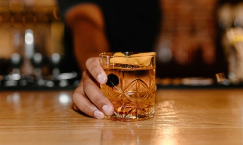 a hand holding holding a cocktail glass
